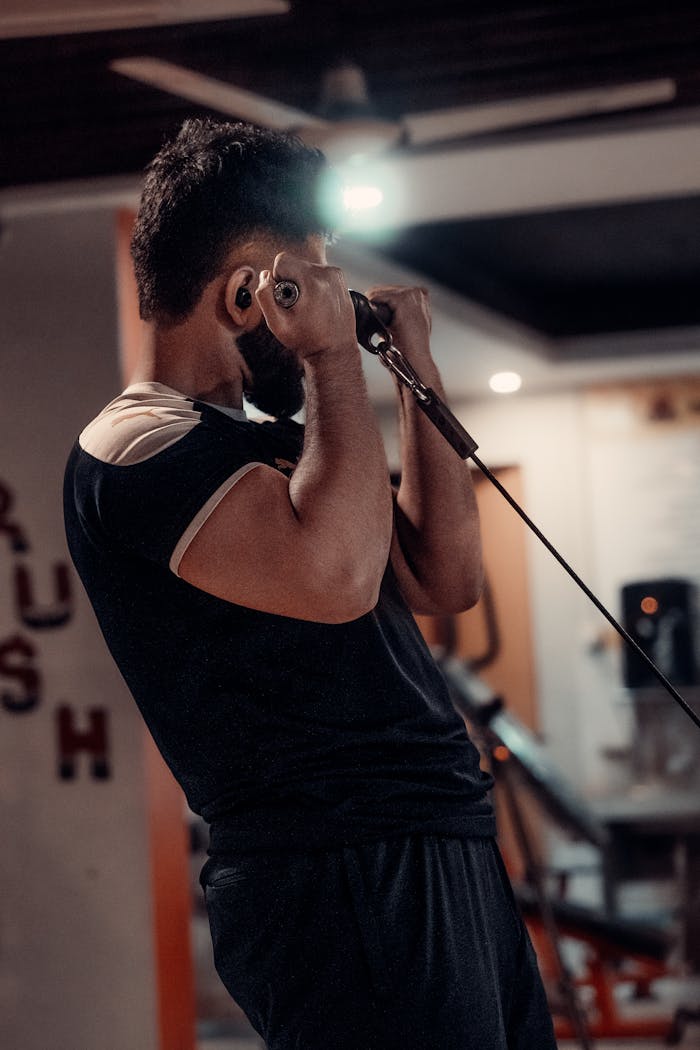 journey Young man focused on strength training using a cable machine in a gym, capturing dedication and fitness motivation.
