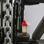 A protein shake bottle on gym equipment symbolizing fitness and health.